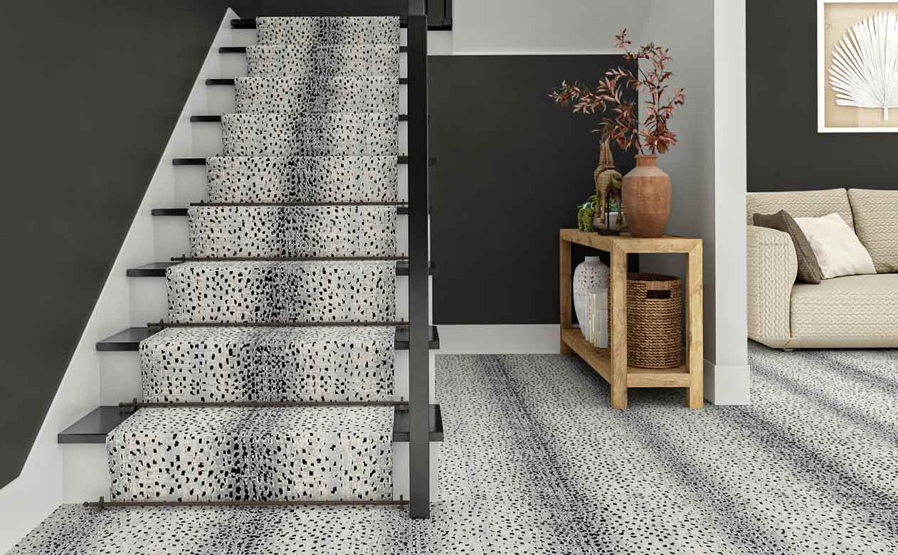 gray animal print carpet in modern entryway with gray walls, styled entry table and staircase